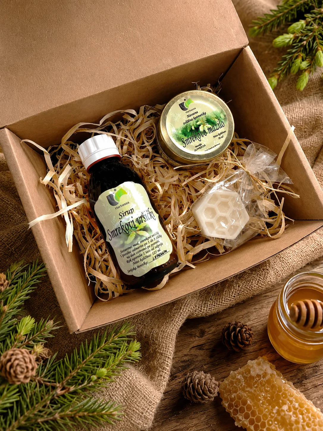 Darilni paket Smreka združuje sirup smrekovi vršički, mini medeno milo in smrekovo mazilo v lični darilni embalaži. Primeren je kot uporabno darilo za ljubitelje zeliščnih izdelkov, domačih okusov in naravne nege.